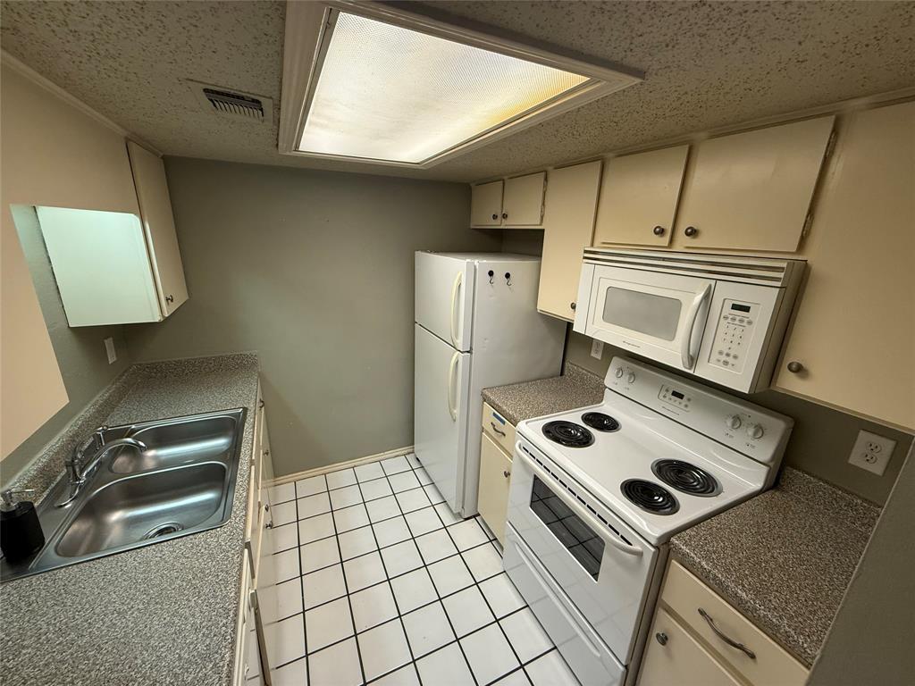2401 Leon Street, Unit 209 Austin, TX 78705 - Photo 3 of 5 a kitchen with a stove and a microwave