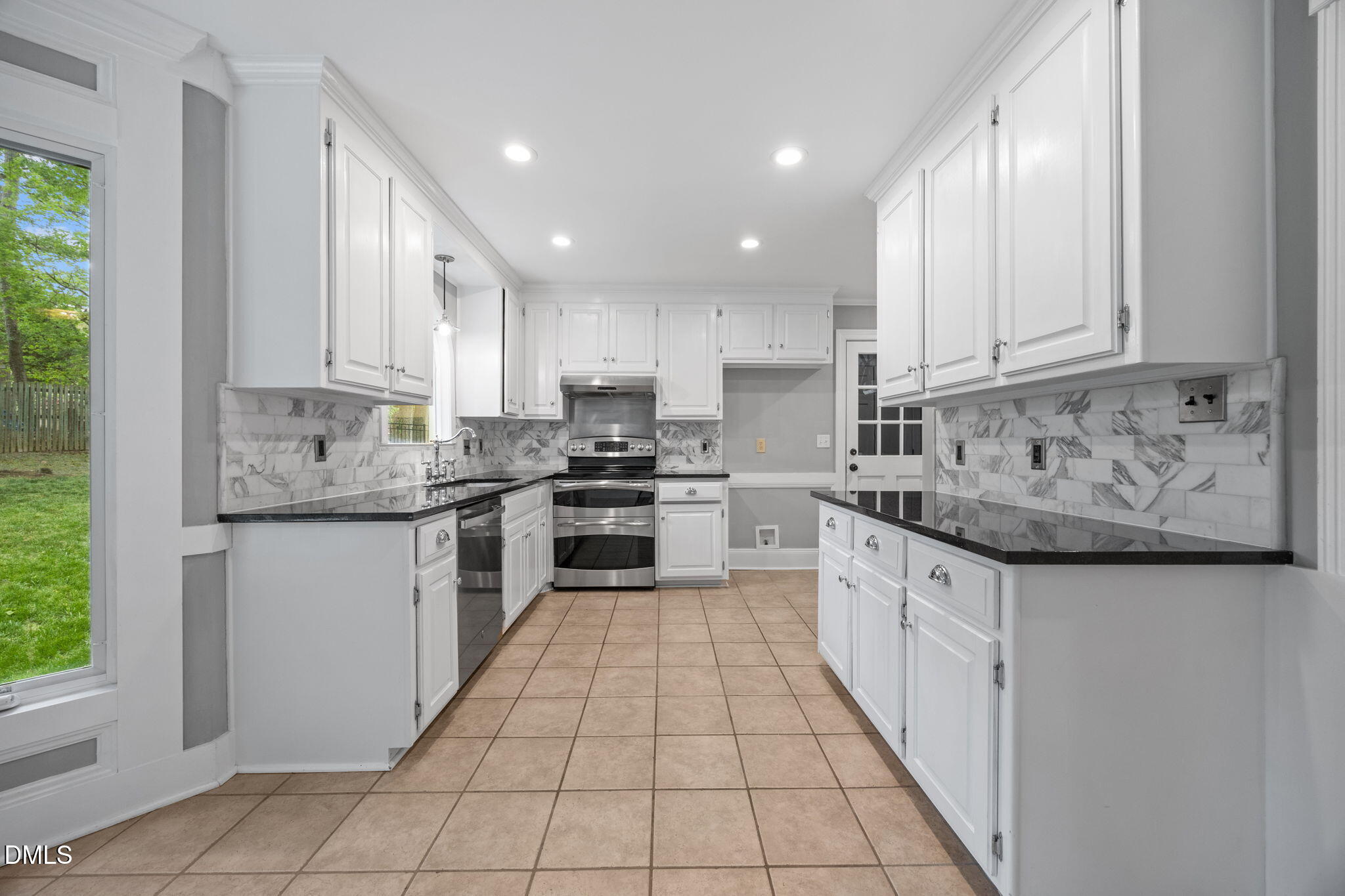 8221 Harps Mill Road Raleigh, NC 27615 - Photo 16 of 46 a kitchen with stainless steel appliances granite countertop a stove a sink and white cabinets