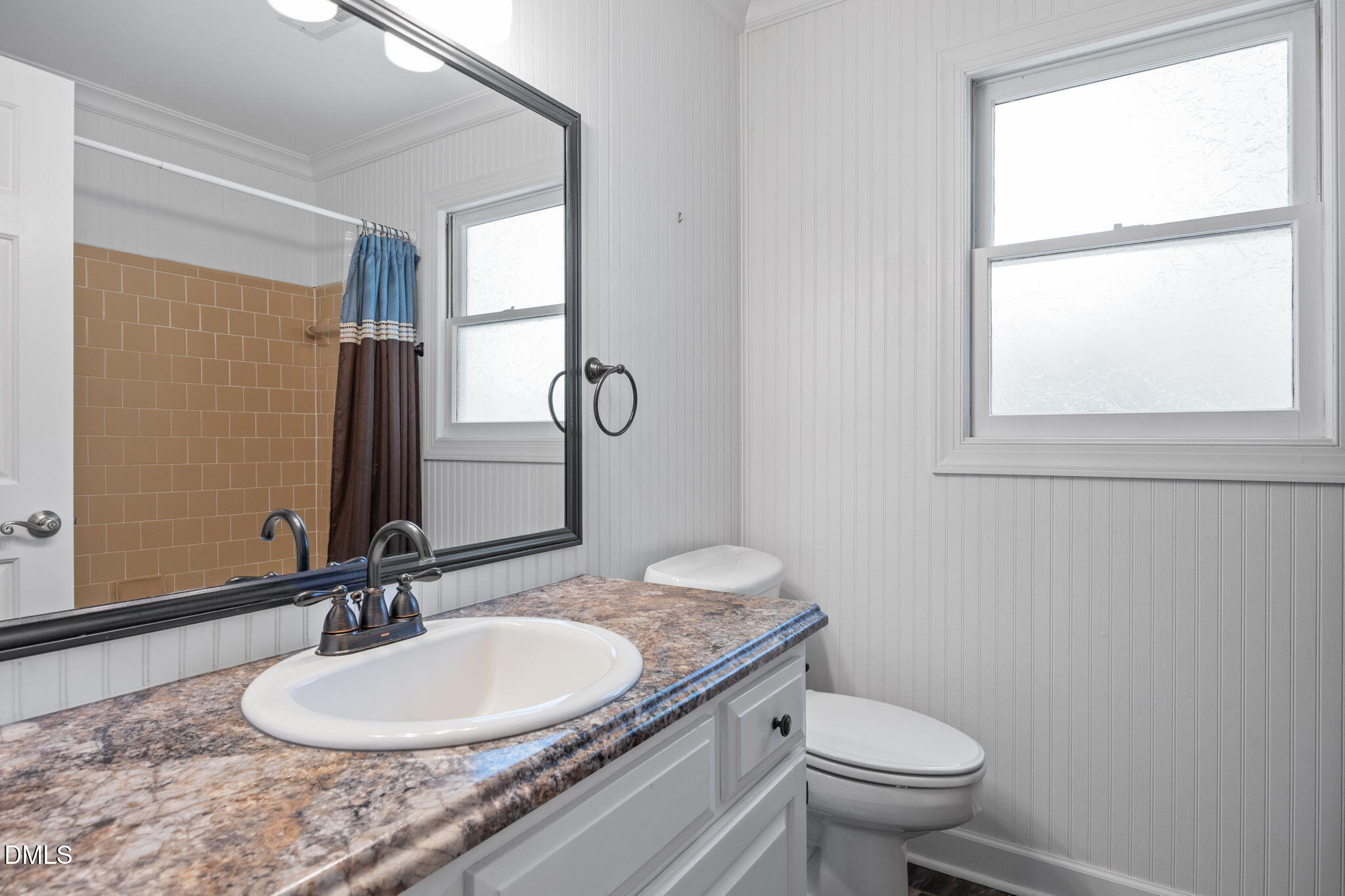 8221 Harps Mill Road Raleigh, NC 27615 - Photo 34 of 46 a bathroom with a granite countertop toilet a sink and a mirror