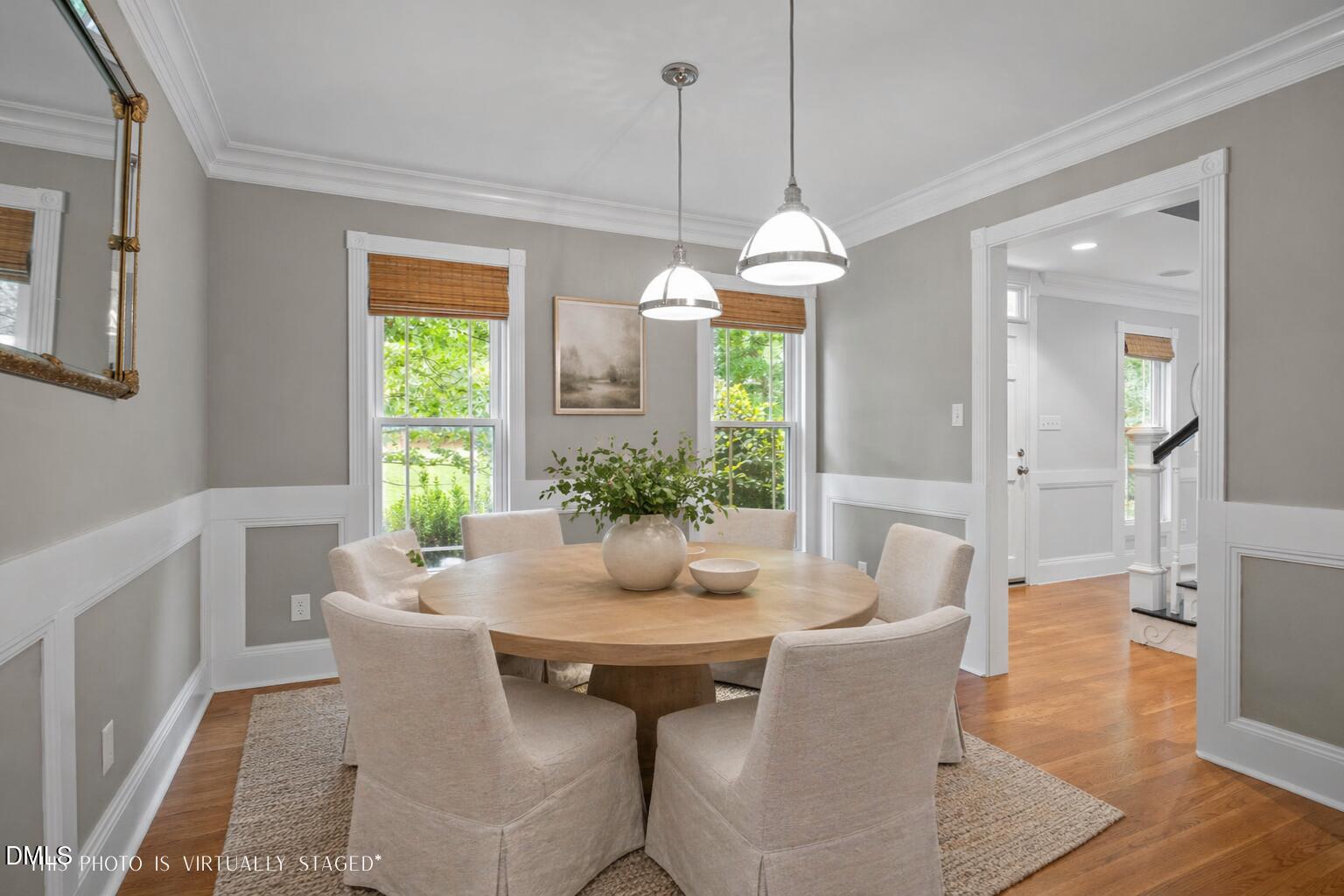 8221 Harps Mill Road Raleigh, NC 27615 - Photo 4 of 46 a dining room with furniture a chandelier and wooden floor