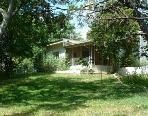 16914 Rocky Ridge Road Austin, TX 78734 - Photo 1 of 1 a backyard of a house with table and chairs potted plants and large tree