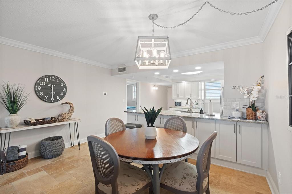 14900 Gulf Boulevard, Unit 202 Madeira Beach, FL 33708 - Photo 12 of 37 a dining room with furniture and a chandelier