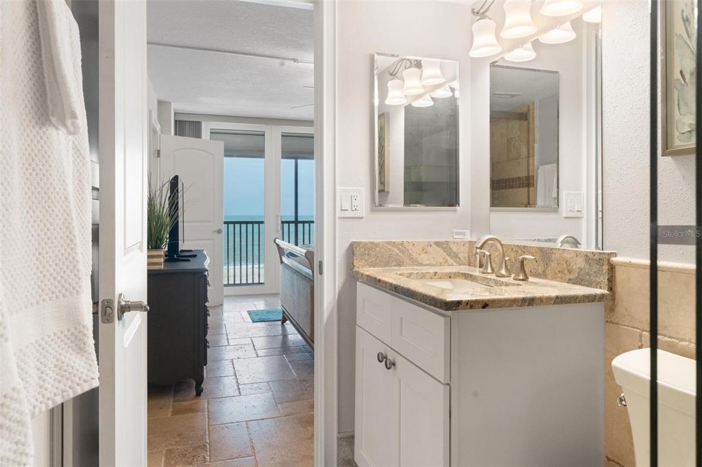 14900 Gulf Boulevard, Unit 202 Madeira Beach, FL 33708 - Photo 18 of 37 a bathroom with a granite countertop sink and a mirror