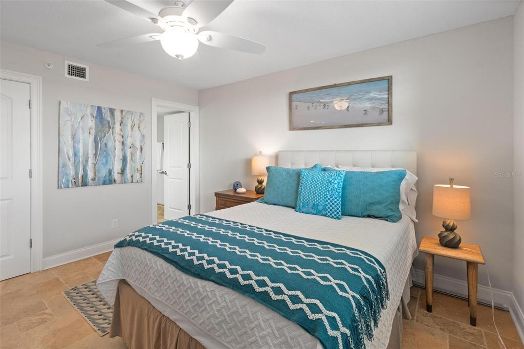 14900 Gulf Boulevard, Unit 202 Madeira Beach, FL 33708 - Photo 20 of 37 a bedroom with a bed and a chandelier