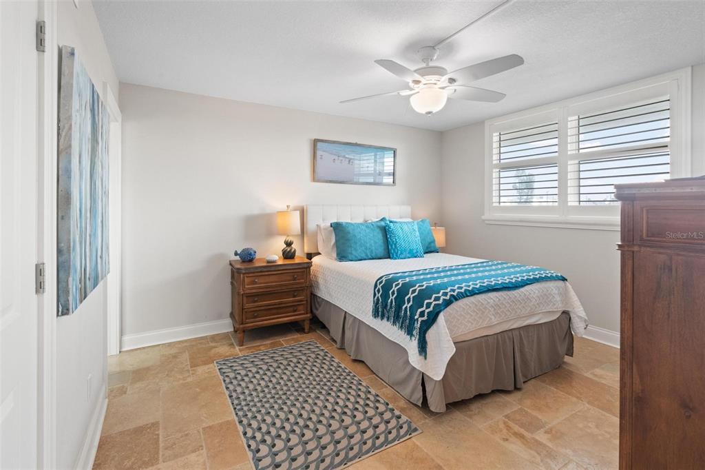 14900 Gulf Boulevard, Unit 202 Madeira Beach, FL 33708 - Photo 21 of 37 a bedroom with a bed and a table with wooden floor