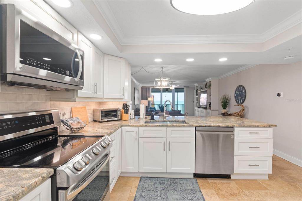 14900 Gulf Boulevard, Unit 202 Madeira Beach, FL 33708 - Photo 5 of 37 a kitchen with a sink stove and cabinets