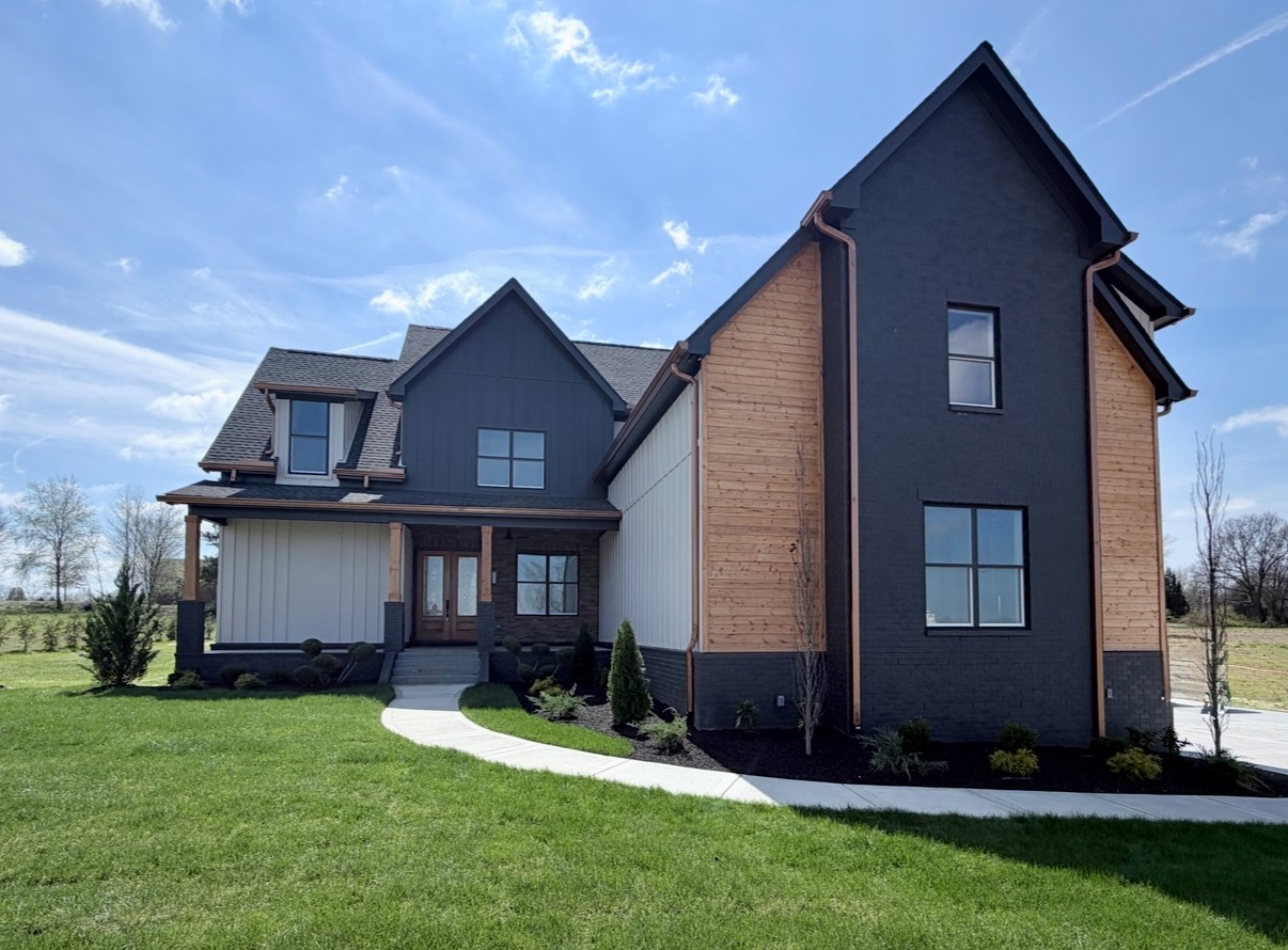 a front view of a house with a yard and outdoor seating