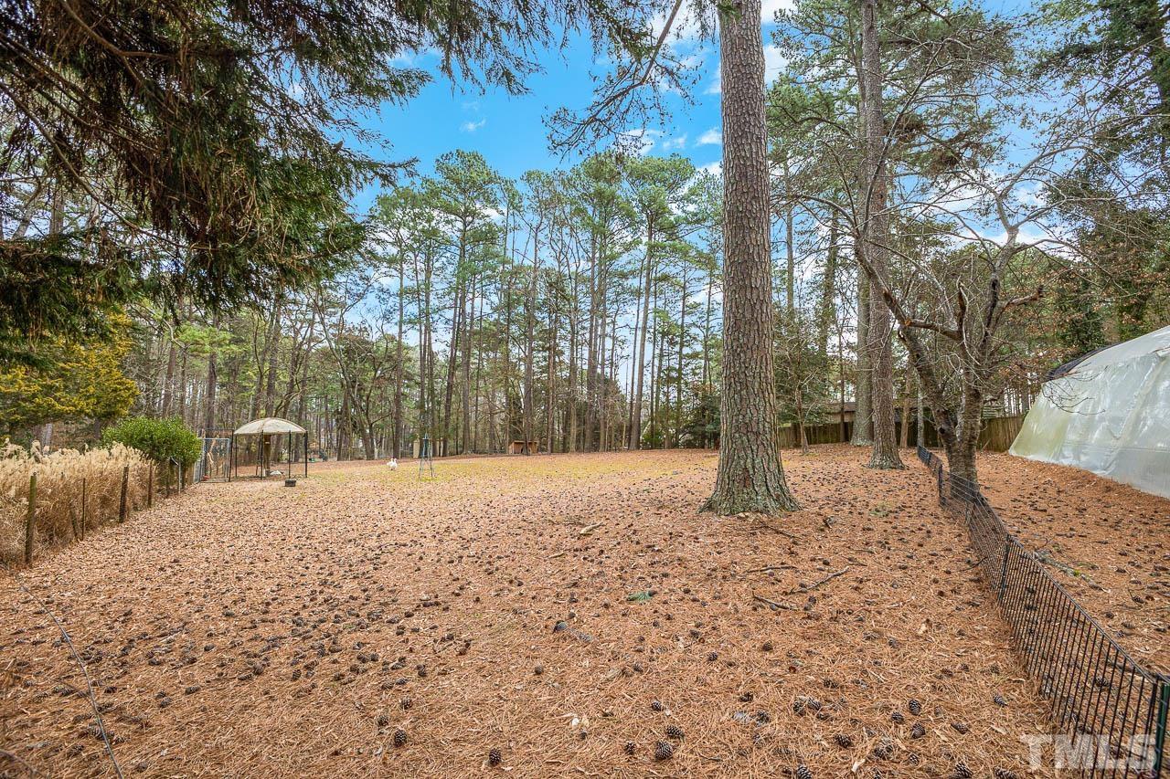 9006 Honeycutt Road Raleigh, NC 27615 - Photo 13 of 54 a backyard of a house with lots of green space