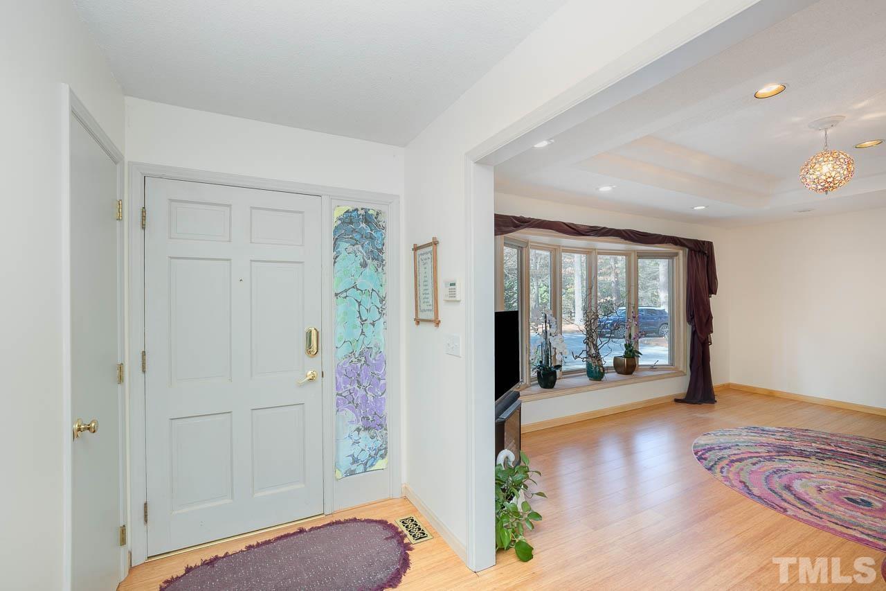 9006 Honeycutt Road Raleigh, NC 27615 - Photo 41 of 54 a view of a hallway with wooden floor and furniture