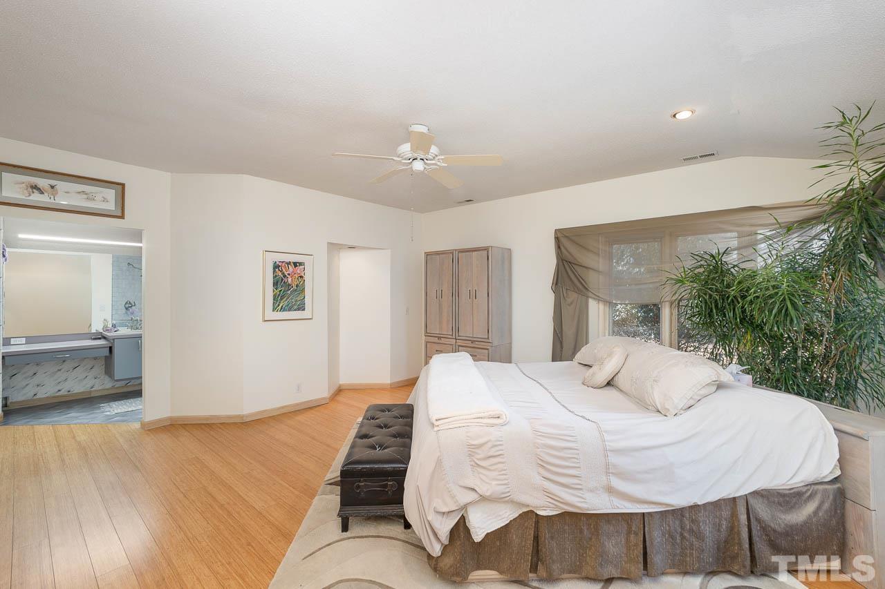 9006 Honeycutt Road Raleigh, NC 27615 - Photo 52 of 54 a bedroom with a bed and a chandelier