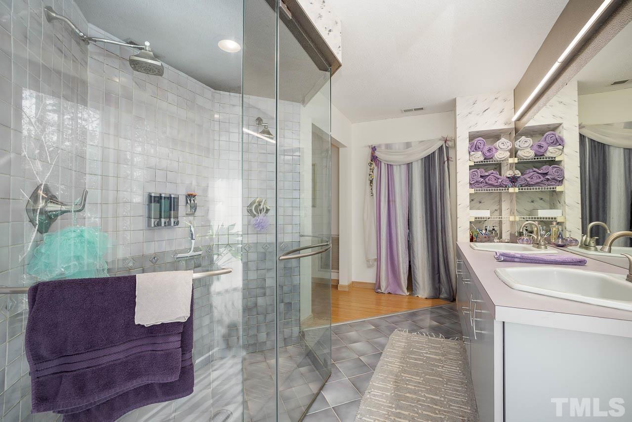 9006 Honeycutt Road Raleigh, NC 27615 - Photo 54 of 54 a spacious bathroom with a tub sink and mirror