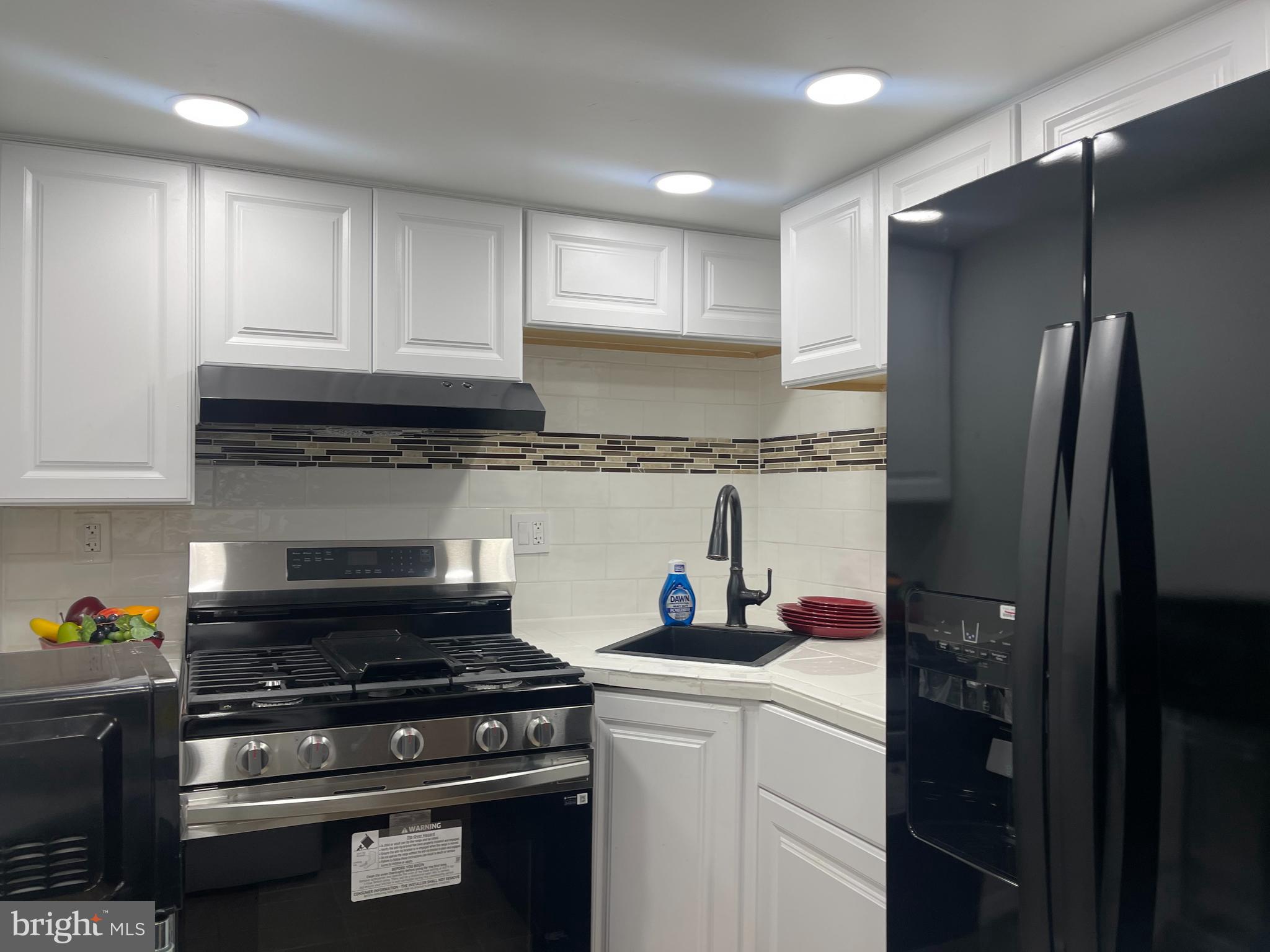 6906 Parkwood Street, Unit C Hyattsville, MD 20784 - Photo 6 of 9 a kitchen with stainless steel appliances granite countertop a stove and a refrigerator