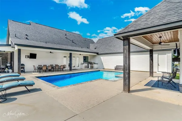 a view of house with swimming pool outdoor seating