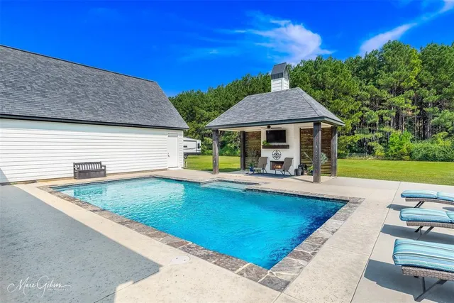 swimming pool view with a seating space