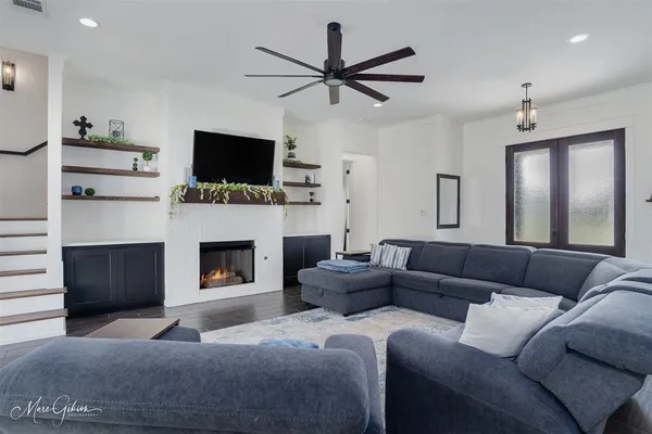 a living room with furniture a ceiling fan and a window