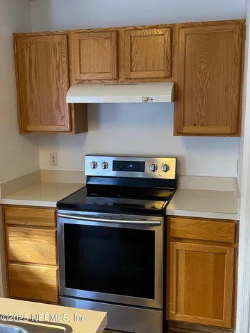 a kitchen with stainless steel appliances granite countertop a refrigerator a sink dishwasher and a stove with wooden floor