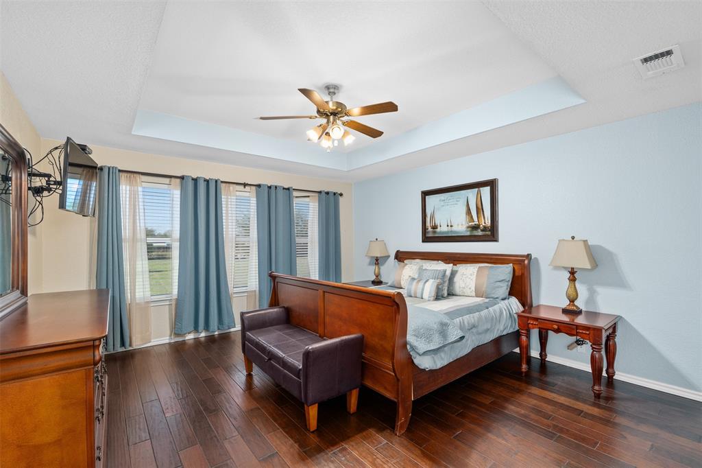 11306 Jennifer Circle Sanger, TX 76266 - Photo 11 of 24 a bedroom with a bed and a chandelier