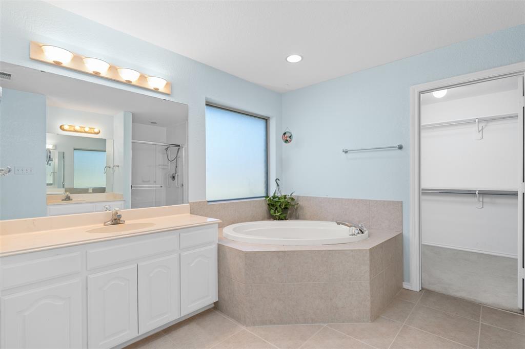 11306 Jennifer Circle Sanger, TX 76266 - Photo 12 of 24 a bathroom with a bathtub a sink a mirror and a bathtub