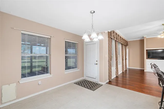a view of a livingroom with wooden floor kitchen view and a window