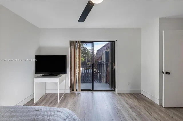 a view of a livingroom with wooden floor and bathroom view