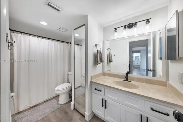 a bathroom with a double vanity sink toilet and shower