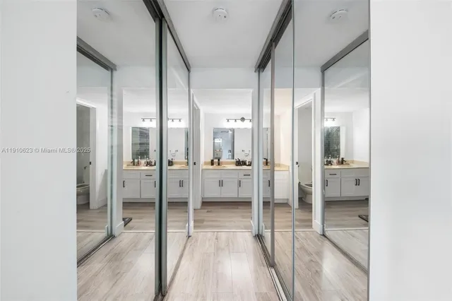 a bathroom with a glass door shower a sink and a mirror