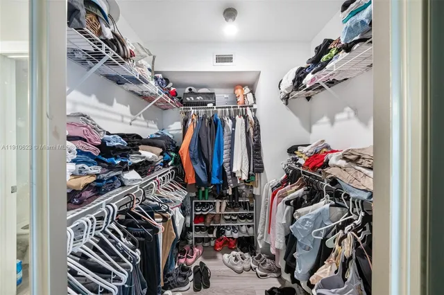 a view of walk in closet with clothes
