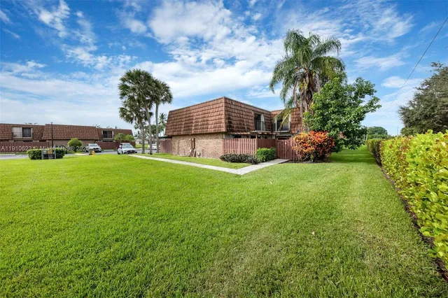 a view of a house with a yard and sitting area