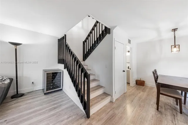 a view of a hallway with wooden floor and stairs