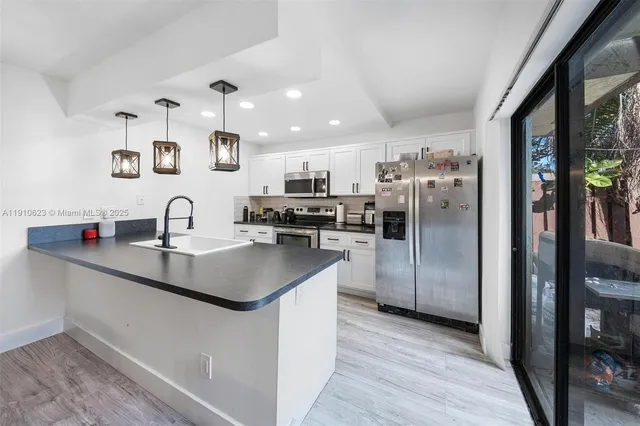 a kitchen with kitchen island a sink stainless steel appliances and cabinets