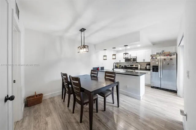 a kitchen with a table chairs refrigerator and cabinets