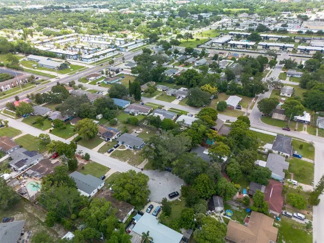 an aerial view of residential houses with outdoor space and trees