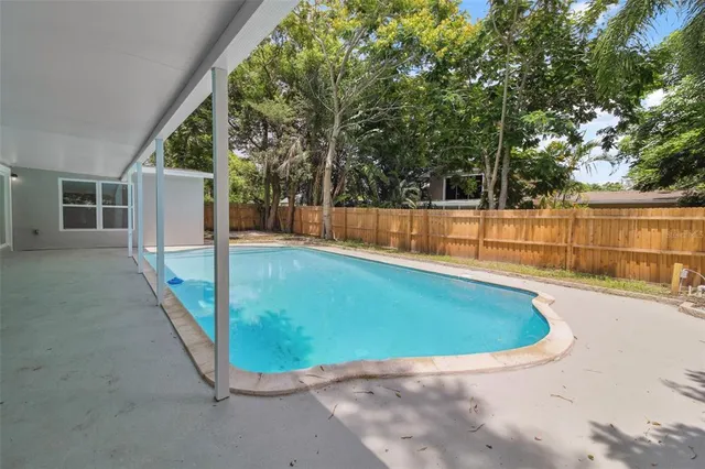 a view of a swimming pool with an outdoor seating and a forest