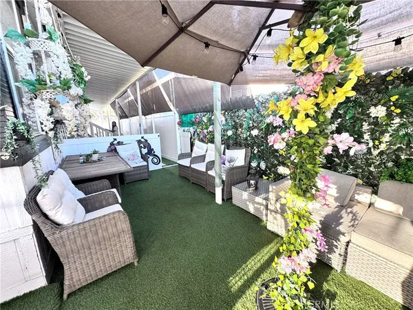 a view of a patio with couches table and chairs and potted plants