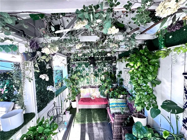 a view of a patio with couches table and chairs and potted plants