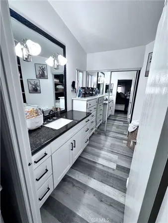 a en suite bathroom with a granite countertop sink and a mirror