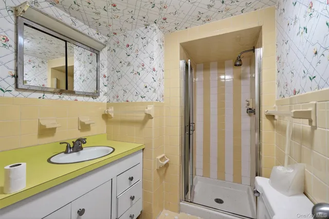 a bathroom with a granite countertop sink a mirror and a shower
