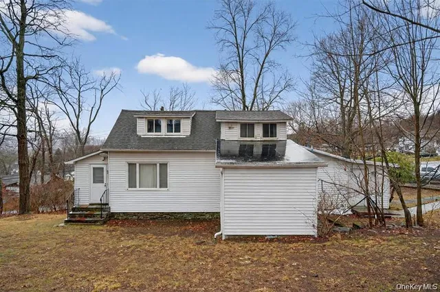 a view of a white house with a large tree