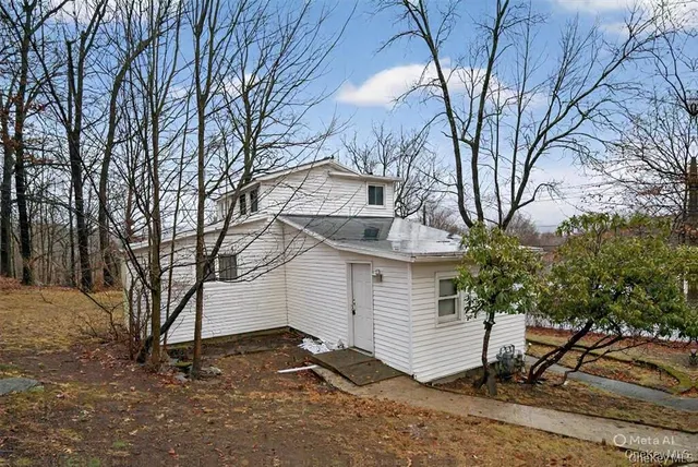 a white house that has a tree in front of it