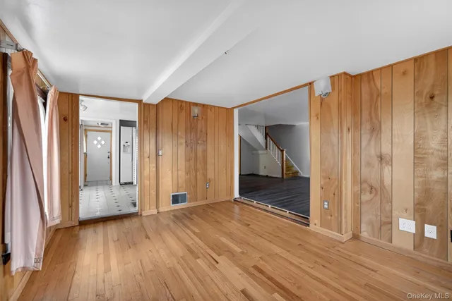 a view of hallway with wooden floor and stairs