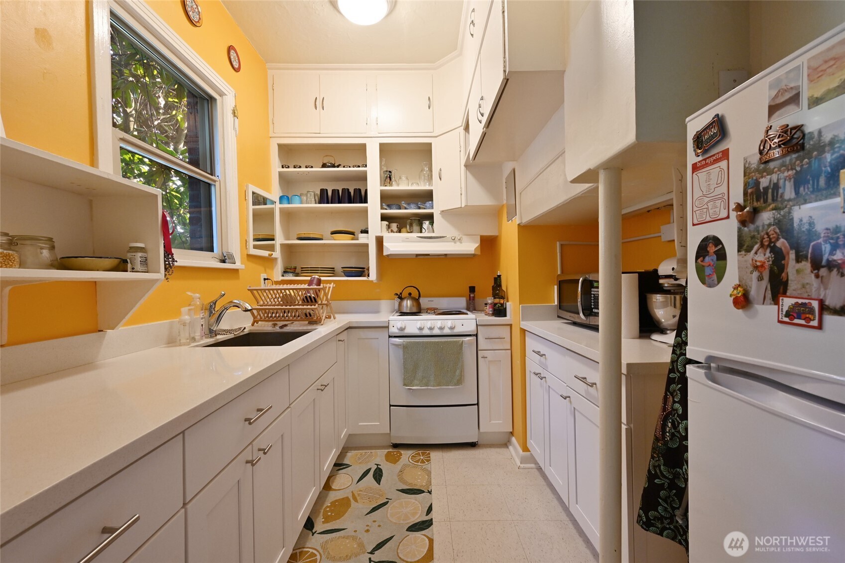 1425 East Prospect Street, Unit 110 Seattle, WA 98112 - Photo 12 of 40 a kitchen with stainless steel appliances granite countertop a sink and cabinets
