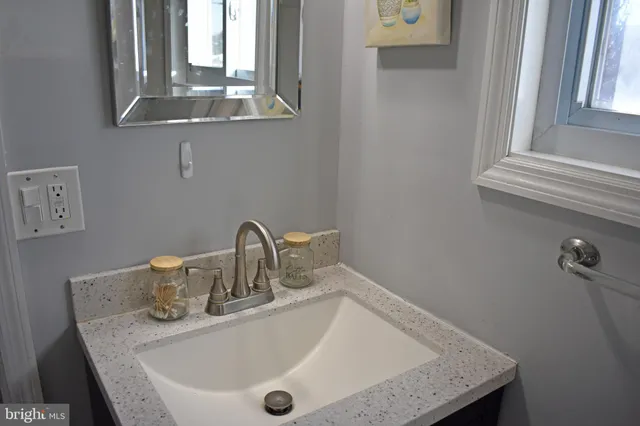 a bathroom with a granite countertop sink and a mirror