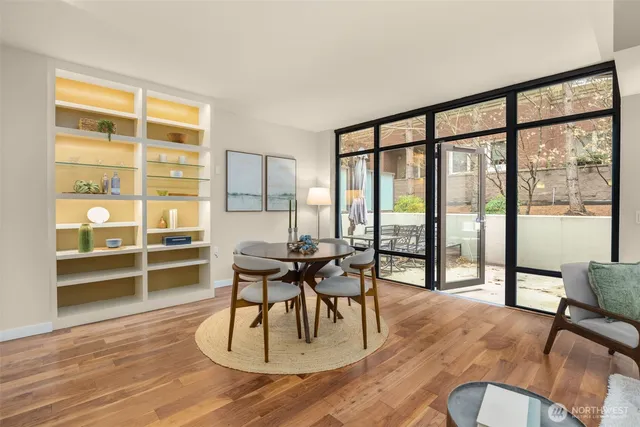 a dining room with wooden floor and windows