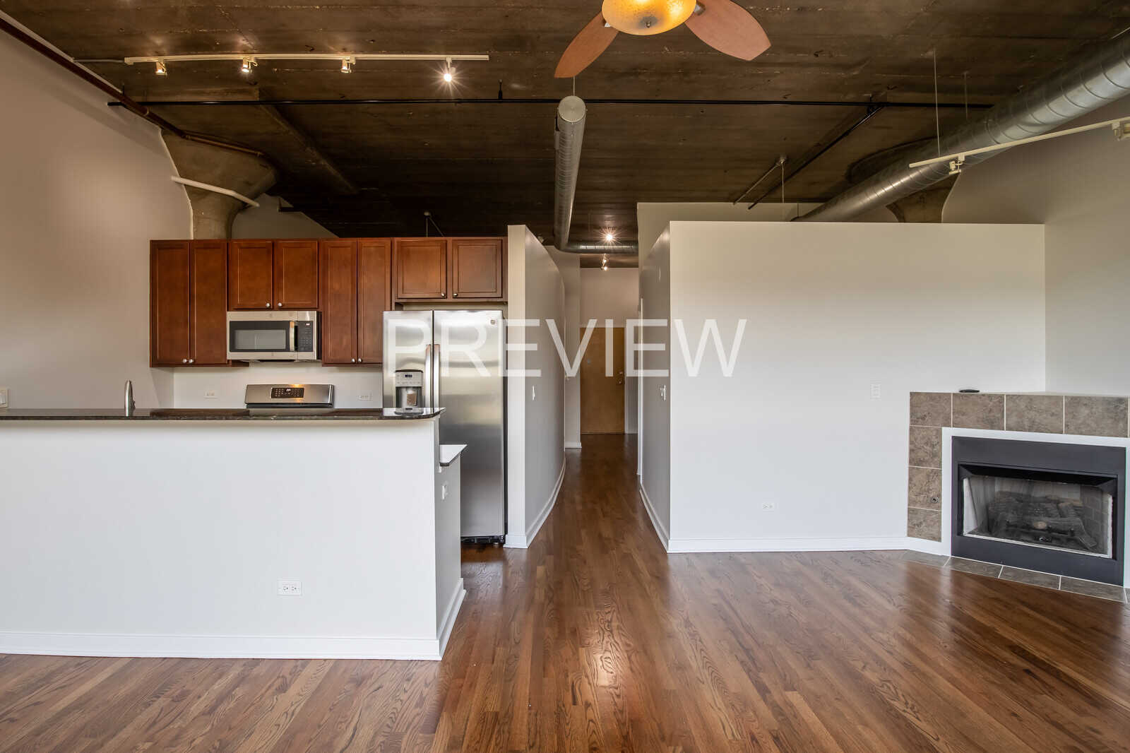 1071 West 15th Street, Unit 351 Chicago, IL 60608 - Photo 5 of 12 a kitchen with stainless steel appliances granite countertop a refrigerator a stove and a wooden floors