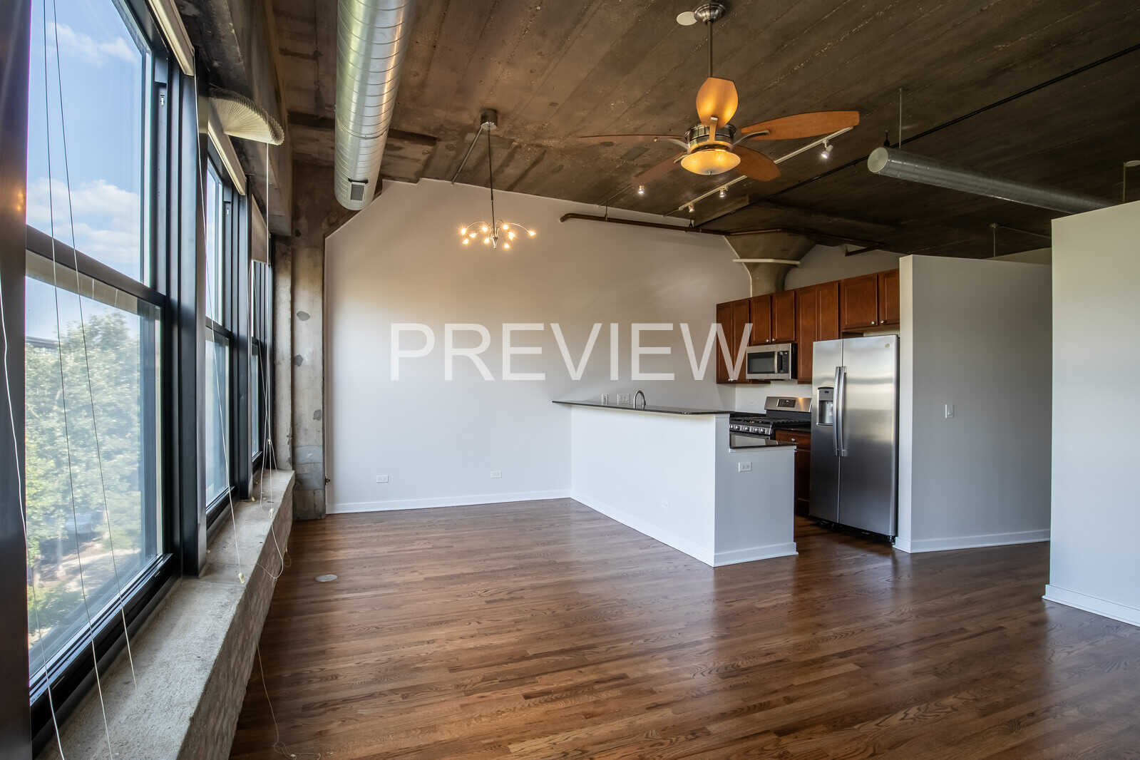 1071 West 15th Street, Unit 351 Chicago, IL 60608 - Photo 6 of 12 a kitchen with stainless steel appliances granite countertop a refrigerator a stove and a wooden floors