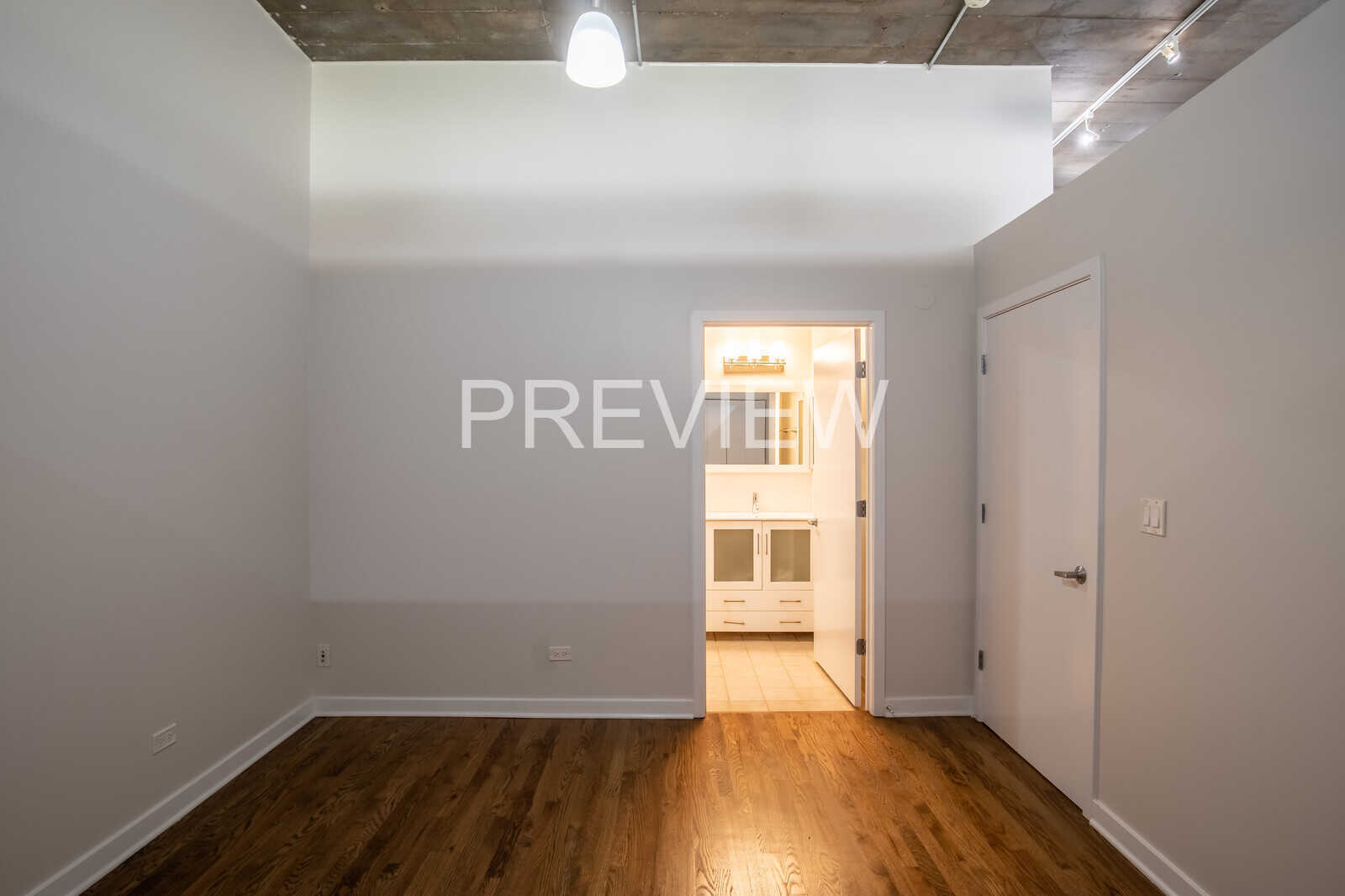 1071 West 15th Street, Unit 351 Chicago, IL 60608 - Photo 10 of 12 a view of an empty room with wooden floor and a window