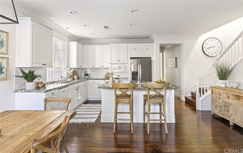 22 Alcott Street Ladera Ranch, CA 92694 - Photo 14 of 46 a large kitchen with a table chairs and a living room
