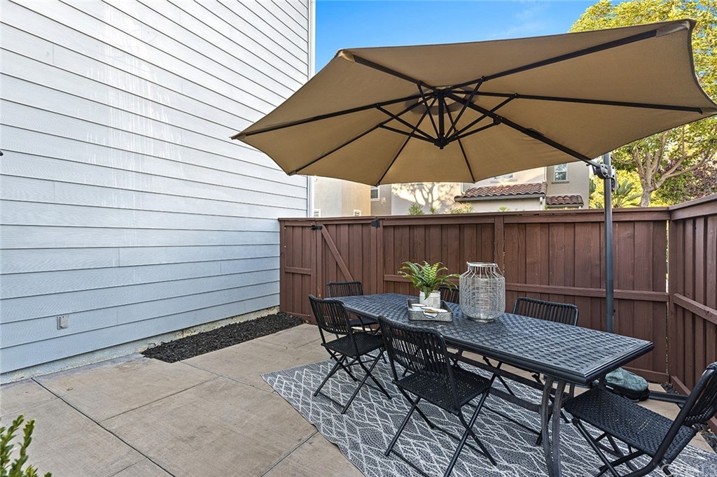 22 Alcott Street Ladera Ranch, CA 92694 - Photo 33 of 46 a view of a roof deck with table and chairs under an umbrella