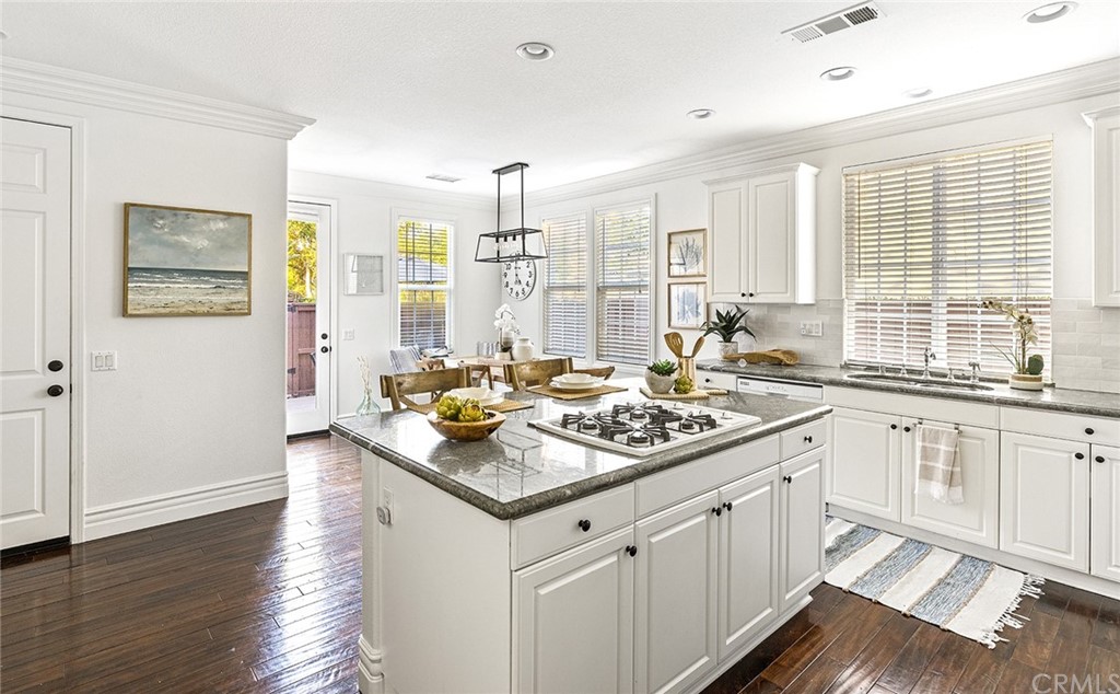 22 Alcott Street Ladera Ranch, CA 92694 - Photo 8 of 46 a kitchen with stainless steel appliances granite countertop a stove a sink and white cabinets with wooden floor