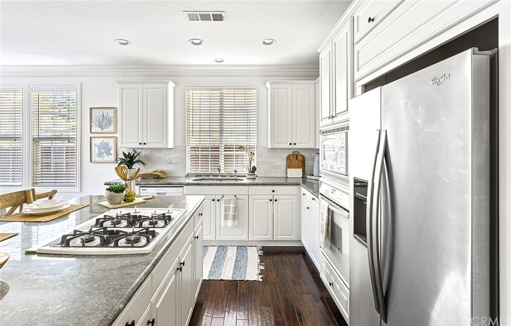 22 Alcott Street Ladera Ranch, CA 92694 - Photo 9 of 46 a kitchen with stainless steel appliances a refrigerator a stove a sink and white cabinets